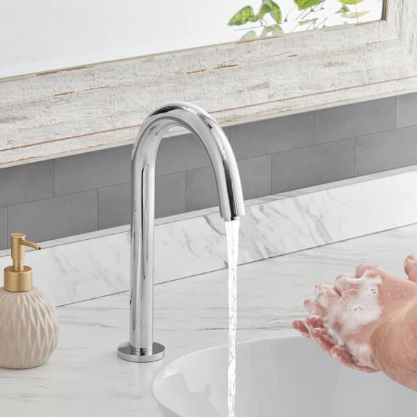 A person washing their hands with a Waterloo deck mount sensor faucet.