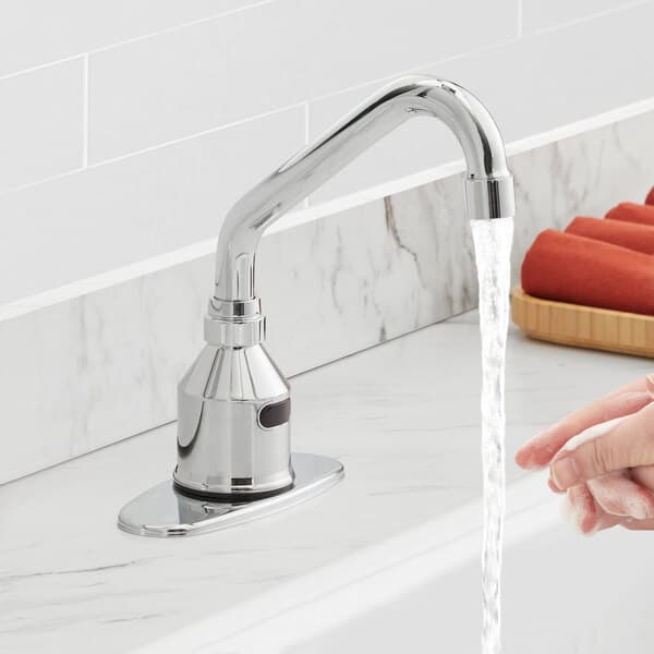 A person washing their hands with soap under a Waterloo hands-free faucet.