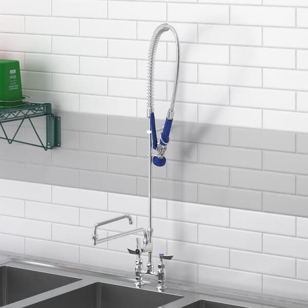 A Waterloo deck-mounted pre-rinse faucet with double-jointed add-on faucet over a kitchen sink.