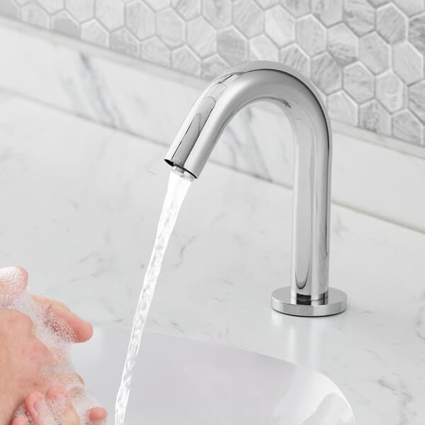 A person washing their hands with a Waterloo deck-mount hands-free faucet.