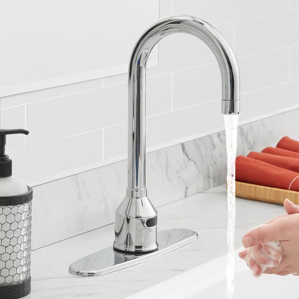 A person washing their hands under a Waterloo hands-free faucet.