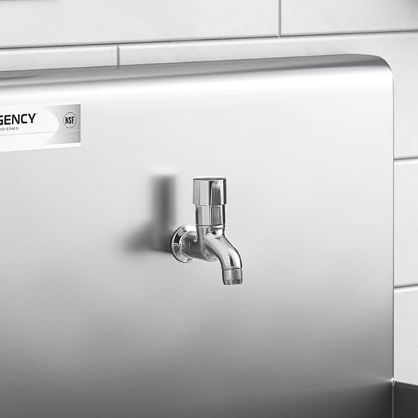 A Waterloo silver wall-mount metering faucet over a silver sink.