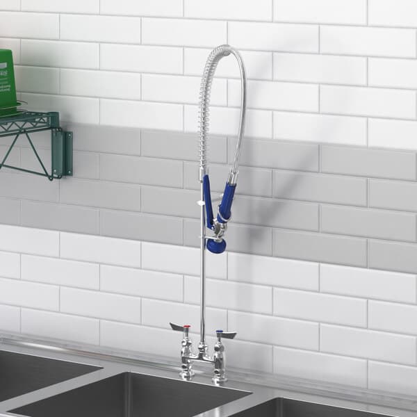 A Waterloo pre-rinse faucet with a hose and spray valve over a kitchen sink.