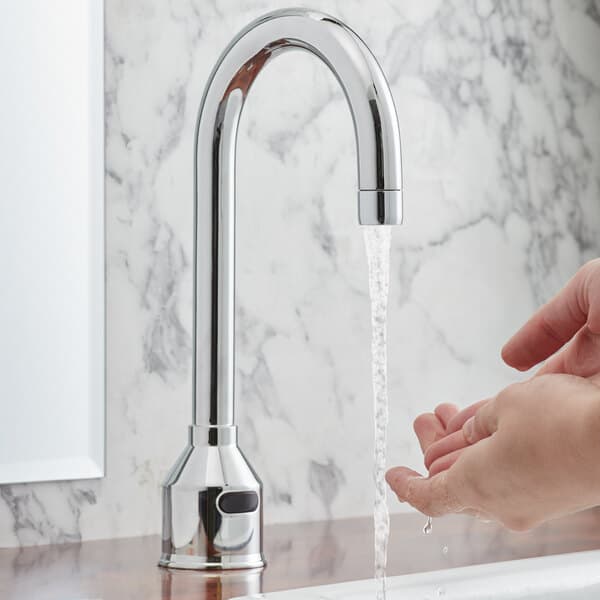 A person washing their hands under a Waterloo deck-mount hands-free sensor faucet with a gooseneck spout.